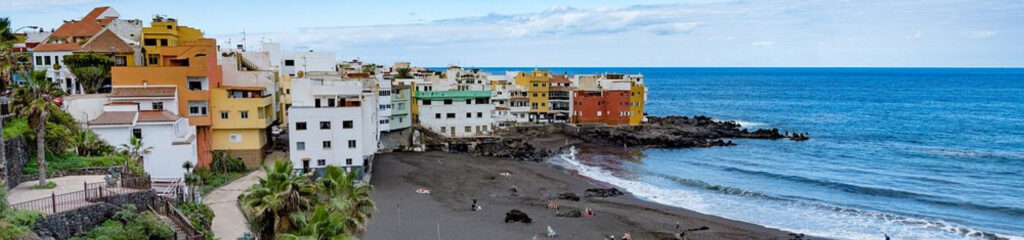 Playa Jardín en Puerto de la Cruz, una playa volcánica rodeada de jardines y palmeras.