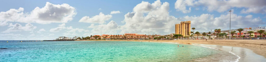Playa de Las Vistas en Tenerife Sur, una de las playas más populares con arena dorada y aguas tranquilas.